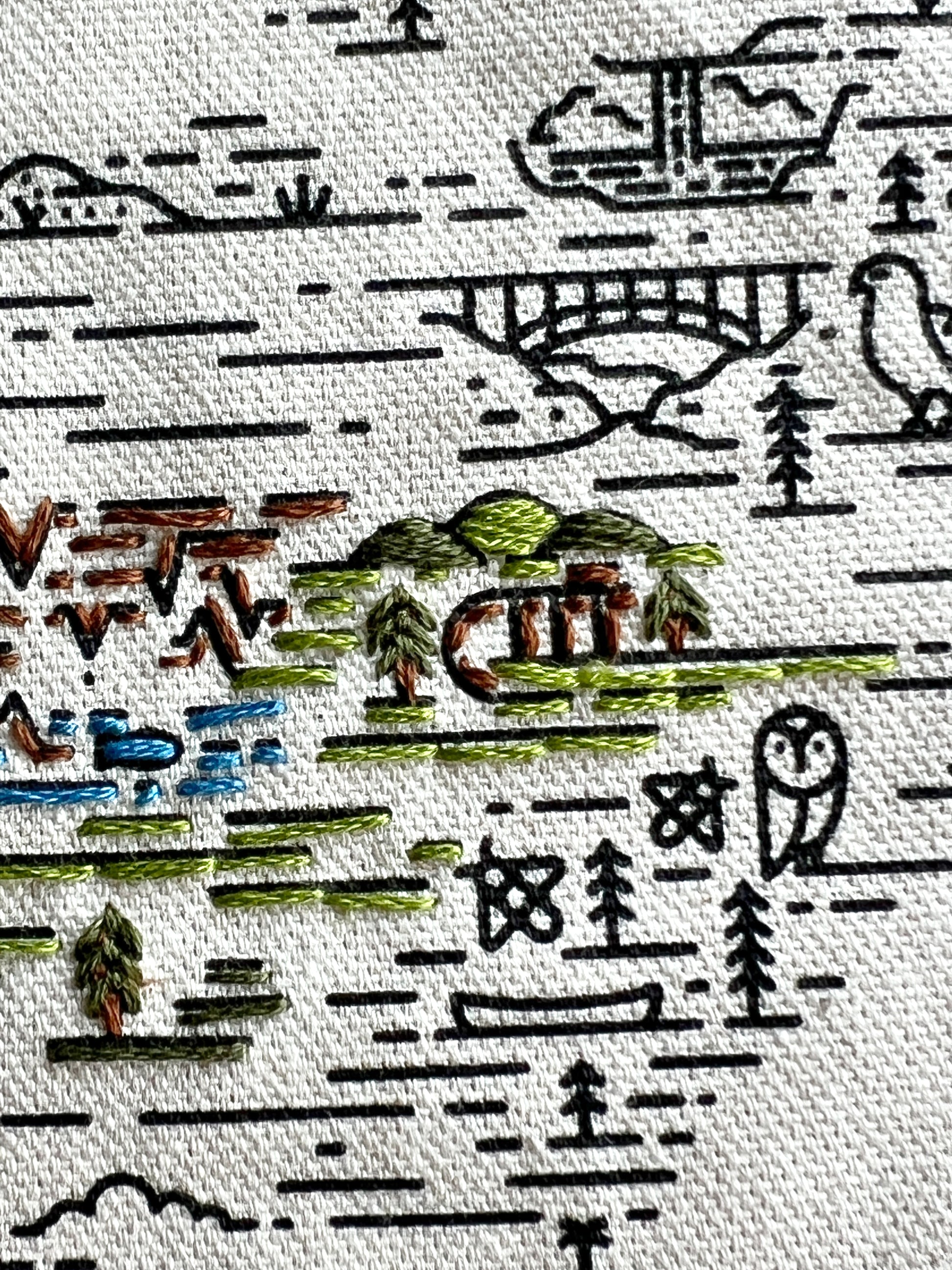 Black screen printing on Cream Canvas tote is highlighted with green, brown and blue stitches. Gateway Arch, Everglades alligator and Great Smokey Mountain National Parks are shown in different stitch styles.