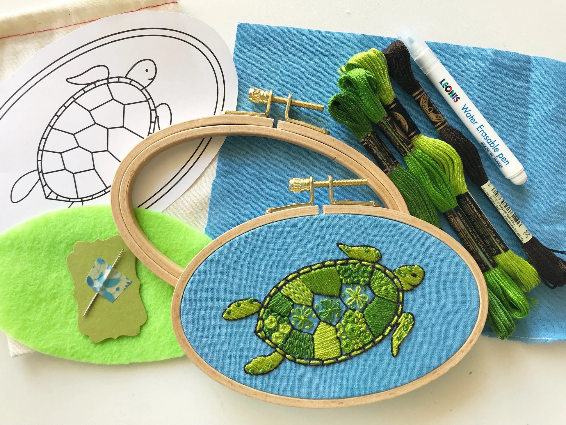 You will need: 4 x 6 inch wooden hoop, 6 x 8 inch linen fabric, water soluble pen, 6 strand embroidery floss, needle, felt for backing, pattern, step-by-step instructions