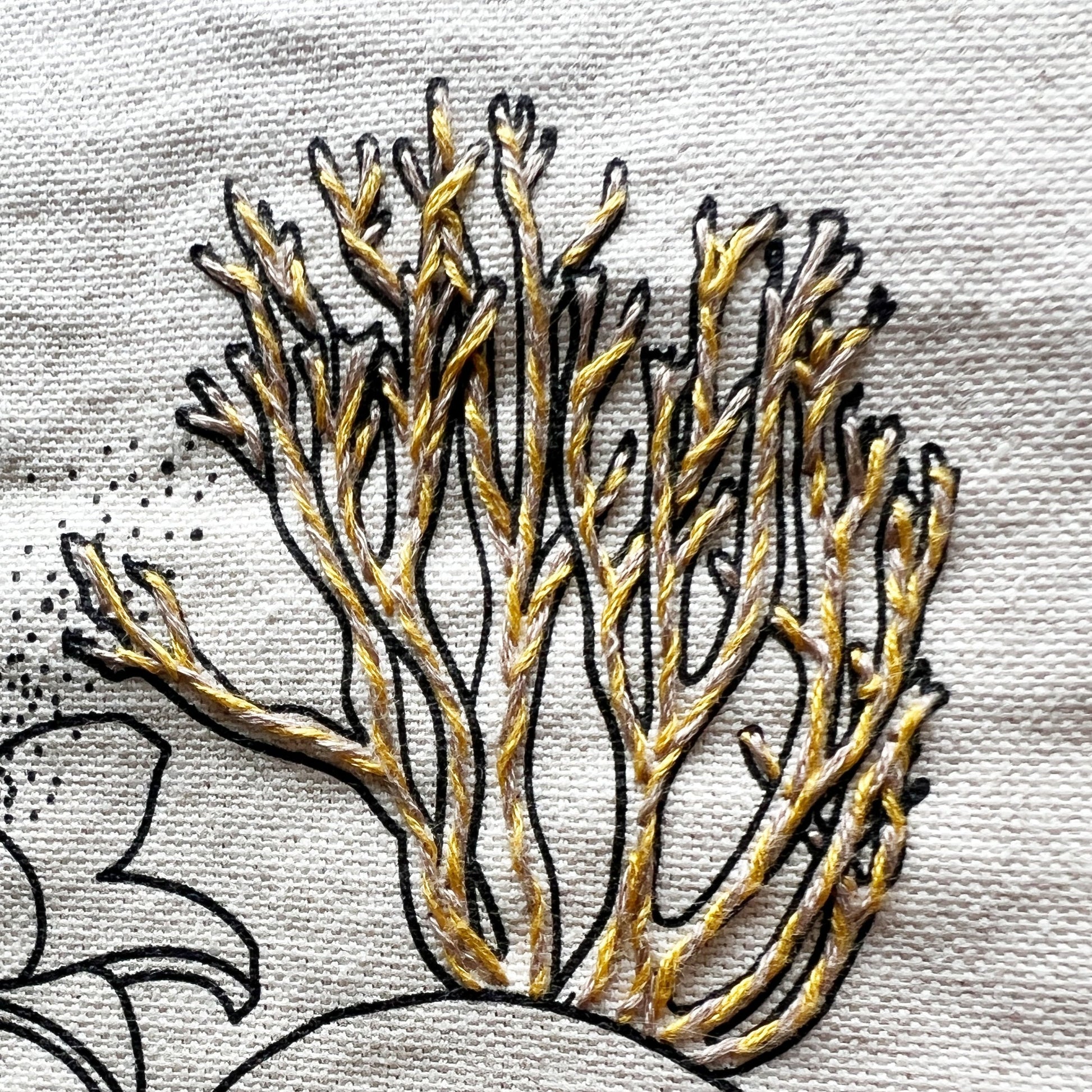 Grow through what you Go through Tote stitch detail.  Intertwined tan and gold stitching inside printed outline of mushroom.