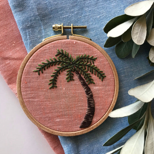 Palm Tree Hand Embroidery PDF.  Detailed colorwork highlights the bark of a palm tree with multicolored palm fronds.