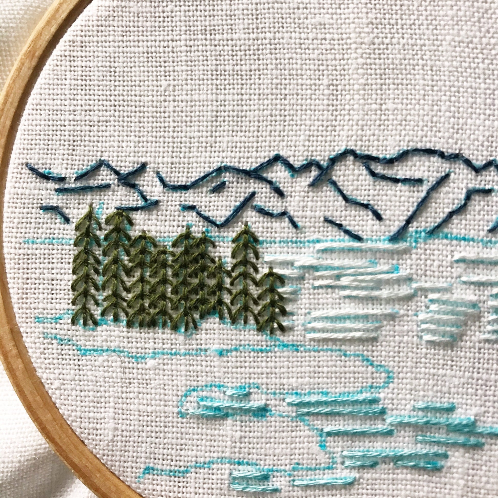 Lake Tahoe is a great pattern to DIY your own modern embroidery hoop art. This 12 page pdf details everything you need to know to stitch this beautiful embroidery.  Mountains in the background with trees, rocks and lake in front.