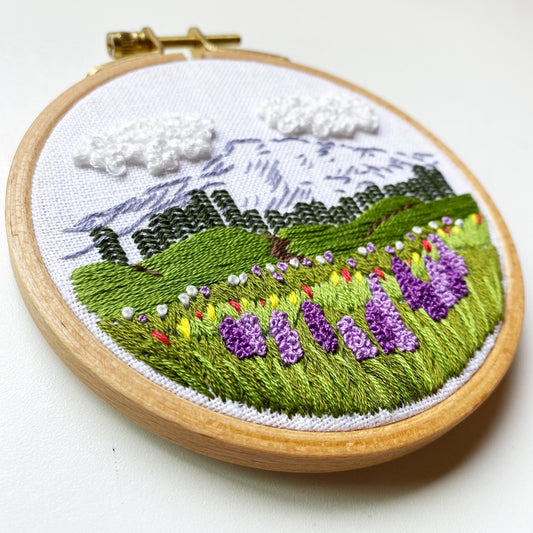 Mount Rainier Embroidery PDF.  Includes pattern for image transfer and 14 page booklet of easy to follow directions to complete.  Image has Mt Rainier in back with lupine and other small flowers in the foreground.