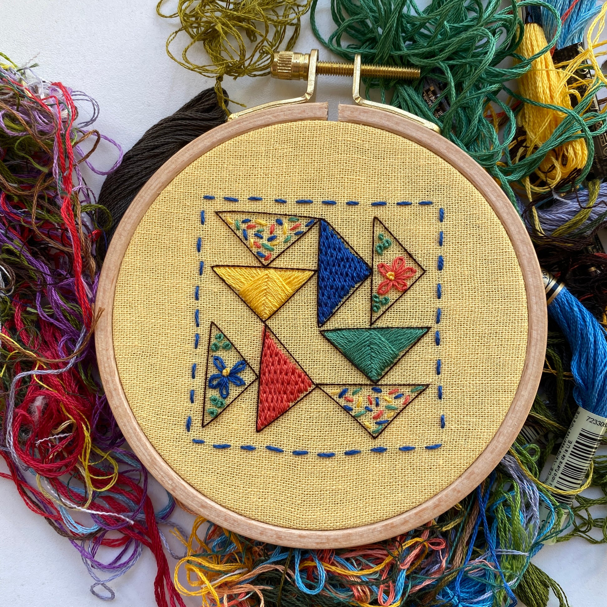 Rosanna Diggs Embroidery Triangle Tango PDF.  Design features a modern take on the traditional flying geese quit pattern.  Learn new stitches while making something beautiful. PDF includes pattern and 12 pages of easy to follow directions.