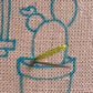 Cozy Cactus Kit in progress.  Green embroidery floss on pink linen with blue marker showing design.