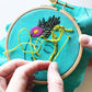Zen Zoe Kit in progress. Needle showing knot in green over turquois linen.