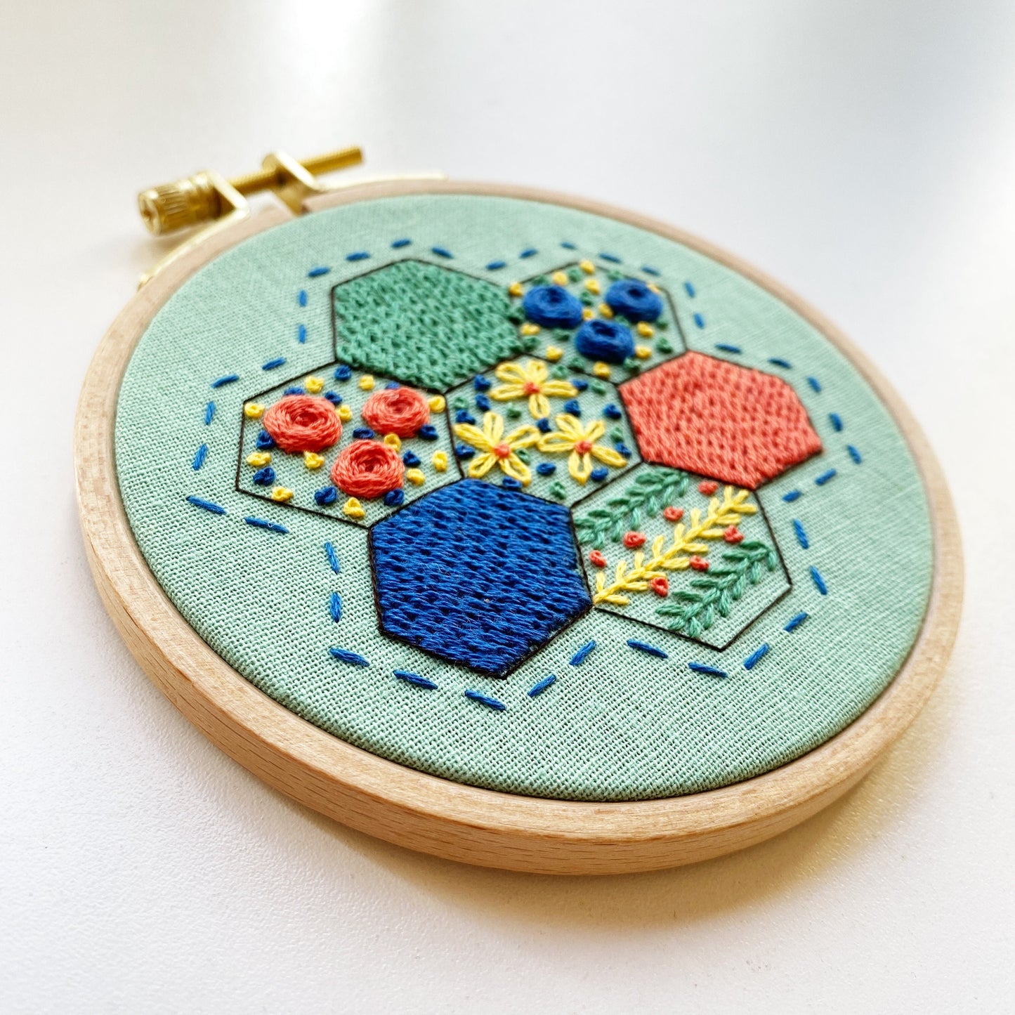 Rosanna Diggs Embroidery Hexie Harmony PDF.  Design features a modern take on the traditional paper pieced hexagon quilt pattern.  Learn new stitches while making something beautiful. PDF includes pattern and 12 pages of easy to follow directions.